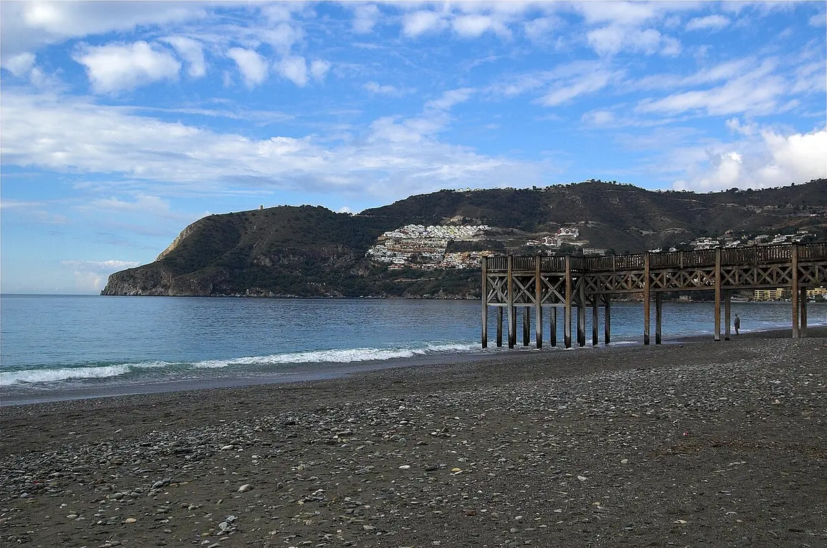 Playa de La Herradura, La Herradura, Granada - horseshoe bay of grey pebbles below green hills