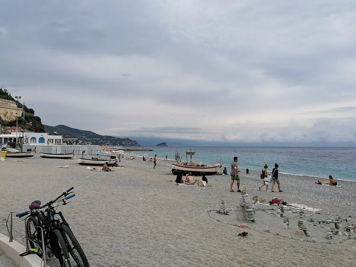 Noli Beach, Liguria, Noli, Savona, Liguria - fishermen beach below a medieval tower on the ligurian coast